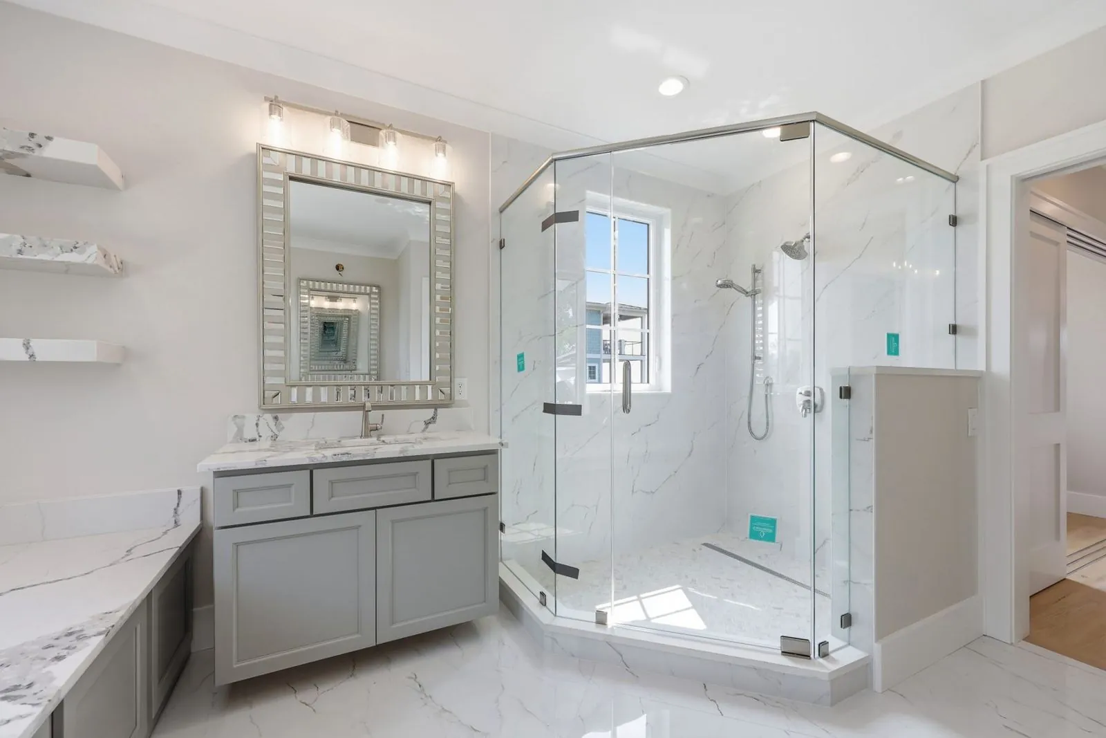 Primary bath with frameless glass shower and marble-look porcelain